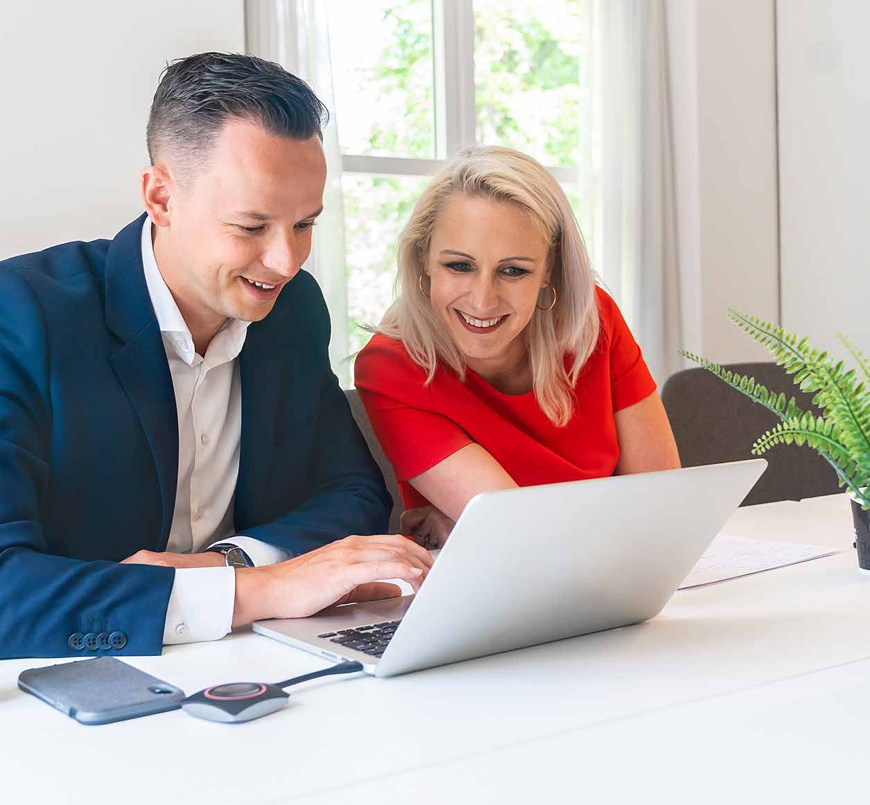 Twee collega’s werken samen aan een laptop